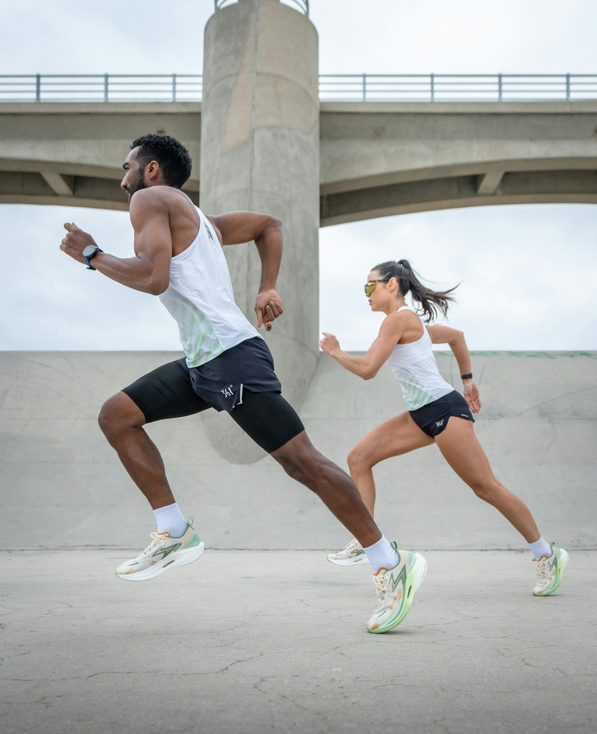 Pareja corriendo con relojes inteligentes y zapatillas de running